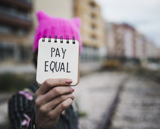 Woman With A Pink Hat And The Text Pay Equal