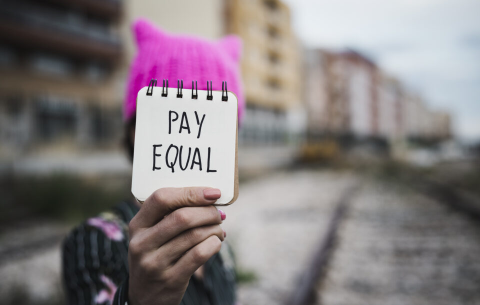 Woman With A Pink Hat And The Text Pay Equal