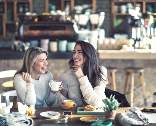 Frauen trinken Kaffee und lachen