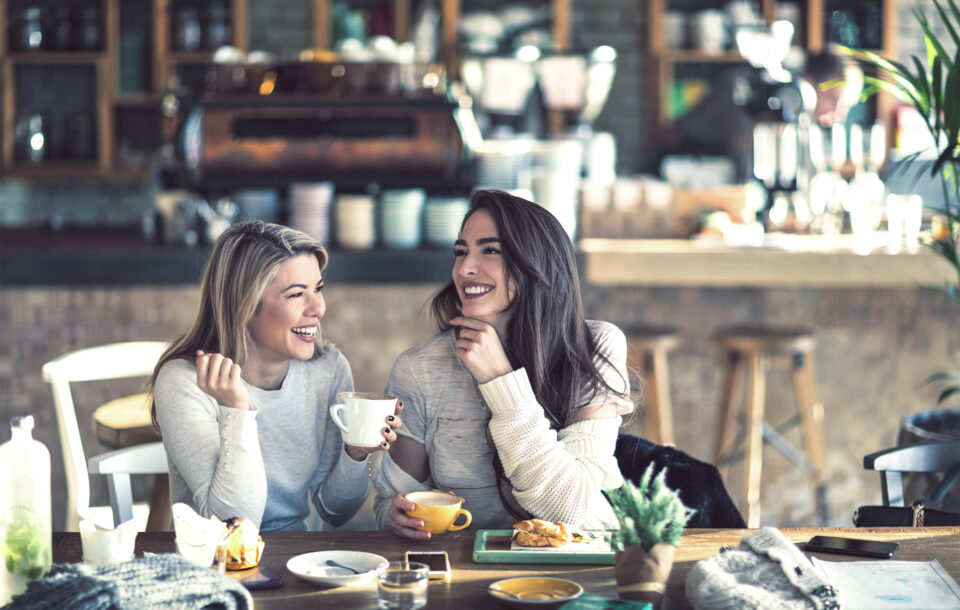 Frauen trinken Kaffee und lachen